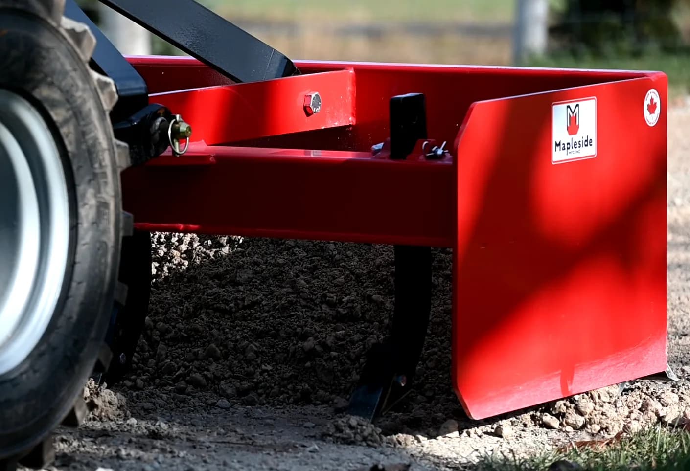 Red Mapleside box blade behind a tractor