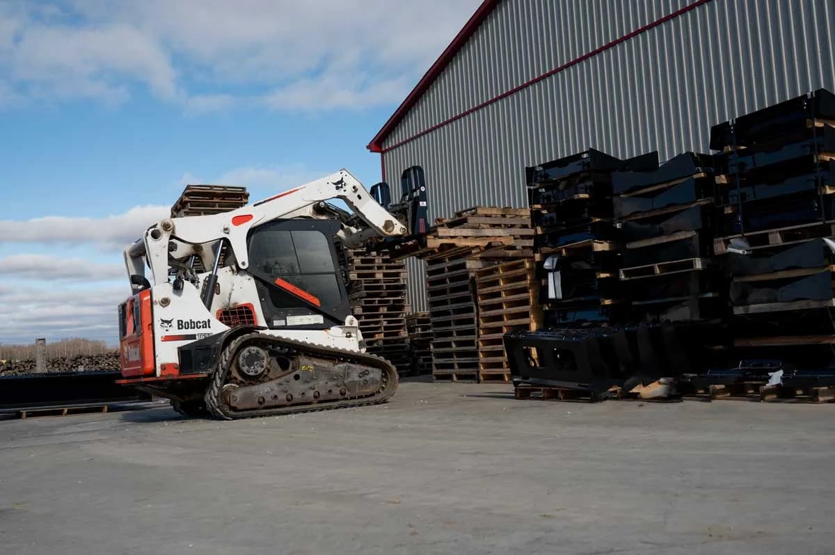 Skid steer moving stacked pallets with pallet forks